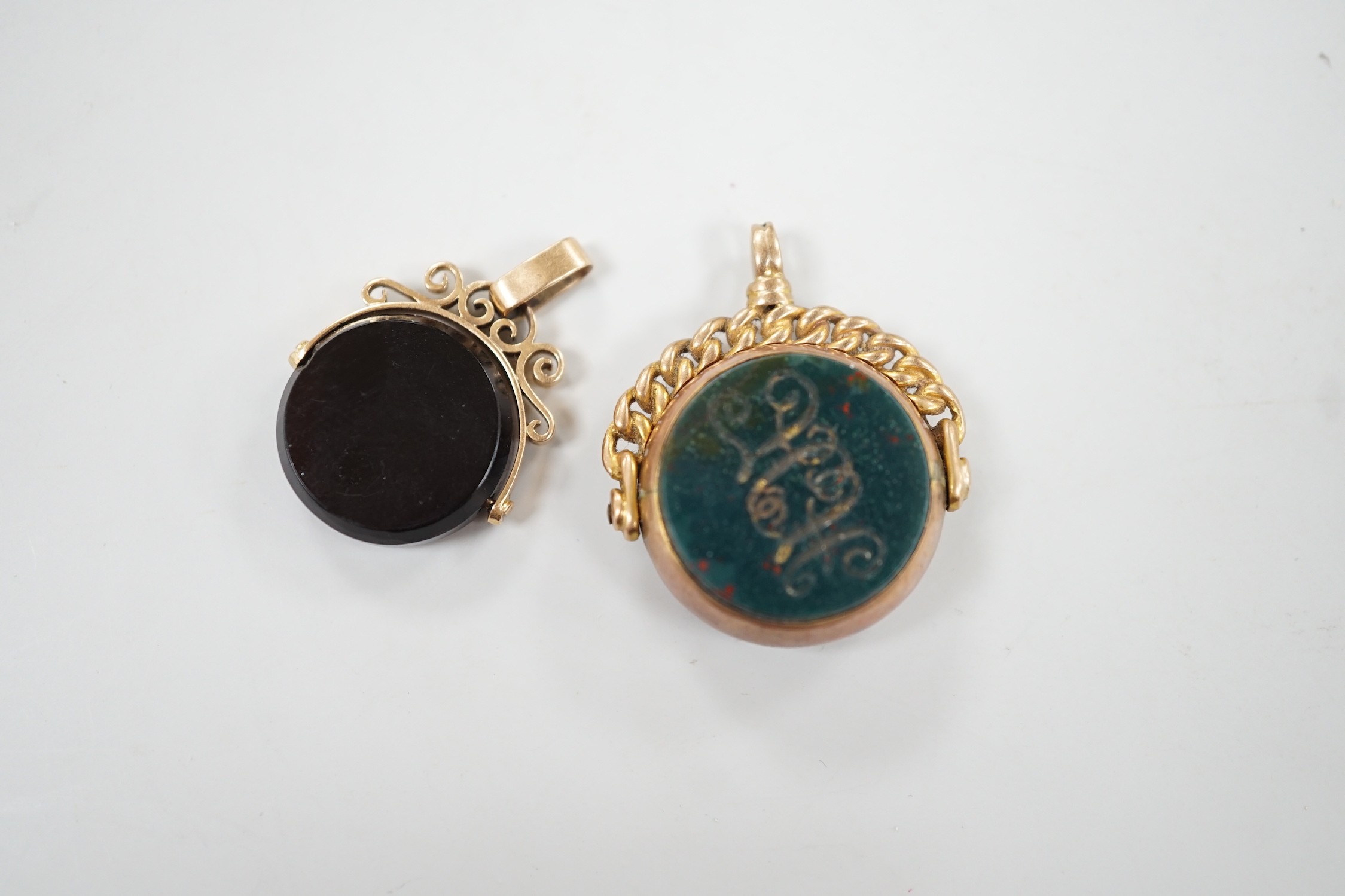 A late Victorian 9ct gold and bloodstone set spinning fob seal, 29mm and one other yellow metal and chalcedony set spinning fob seal.
